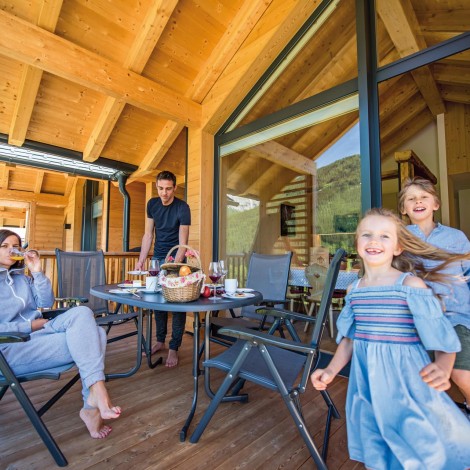 Stabingerhof: Frühstückskorb auf dem Balkon genießen Eine glückliche Familie beim Frühstück auf dem Balkon eines Chalets vom Stabingerhof