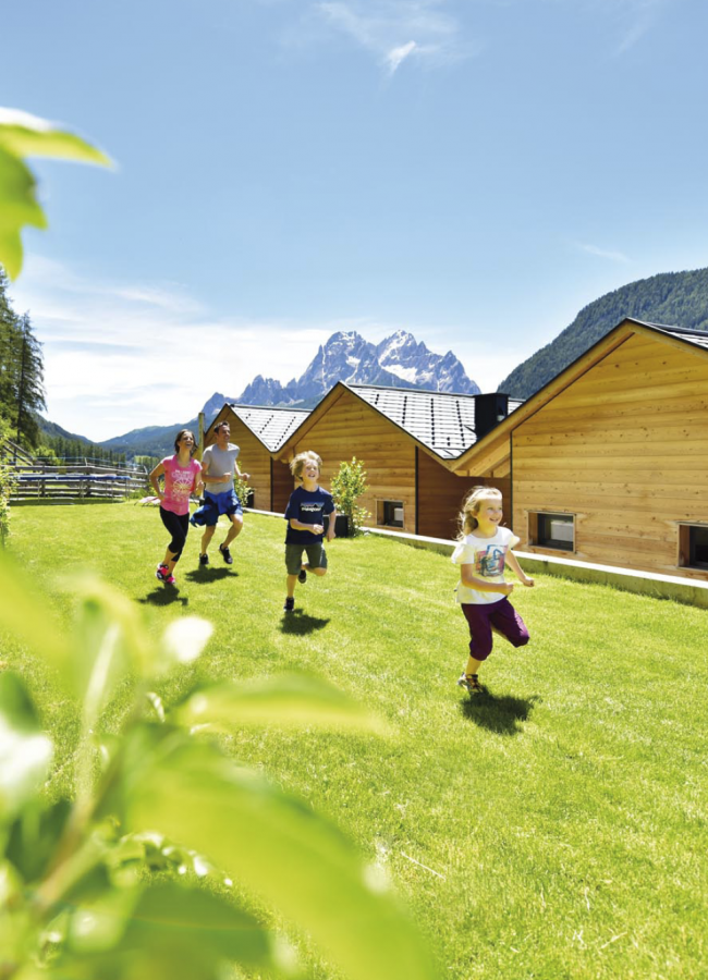 Stabingerhof: Familienurlaub in der Natur Eine glückliche Familie auf der grünen Wiese hinter dem Stabingerhof in Sexten