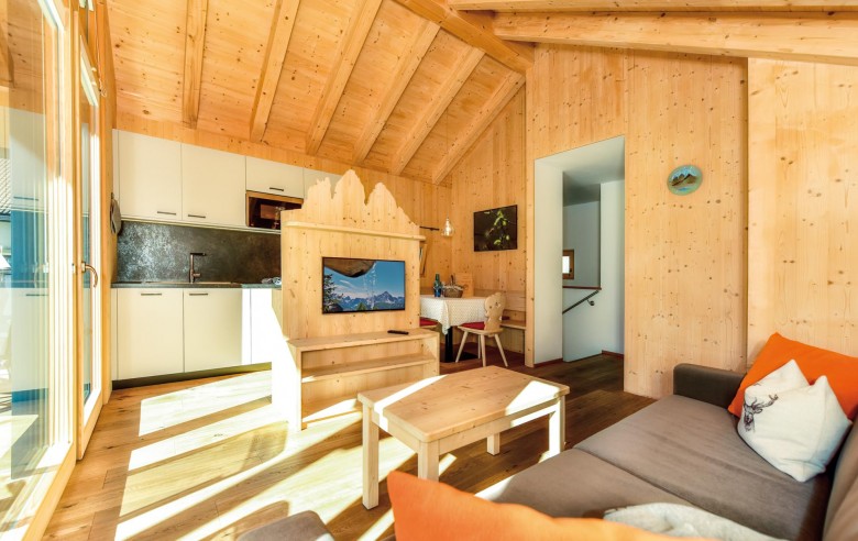 Stabingerhof: Chalets mit Wohnküche und Fernseher Die Wohnküche vom Chalet Timo mit Küchenzeile und Sofa.