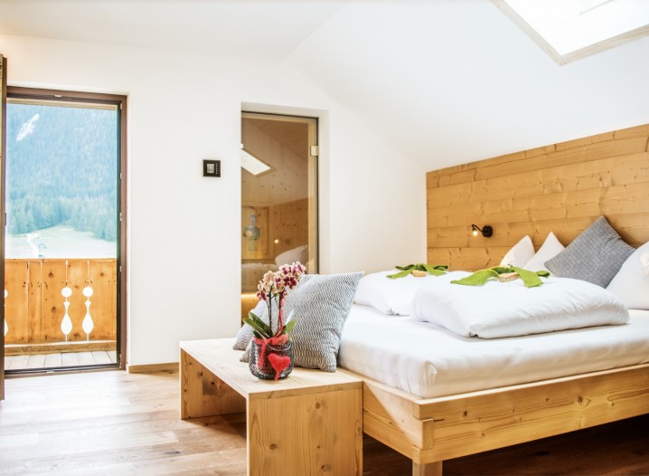 Ein gemütlich eingerichtetes Chaletzimmer in Sexten mit Balkon