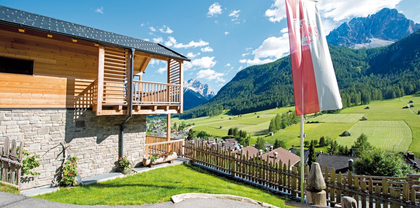 Stabingerhof: Rustikal-modernes Leben in hochwertigen Chalets Die Seitenansicht vom Stabingerhof mit Blick auf die Sextner Dolomiten in Südtirol