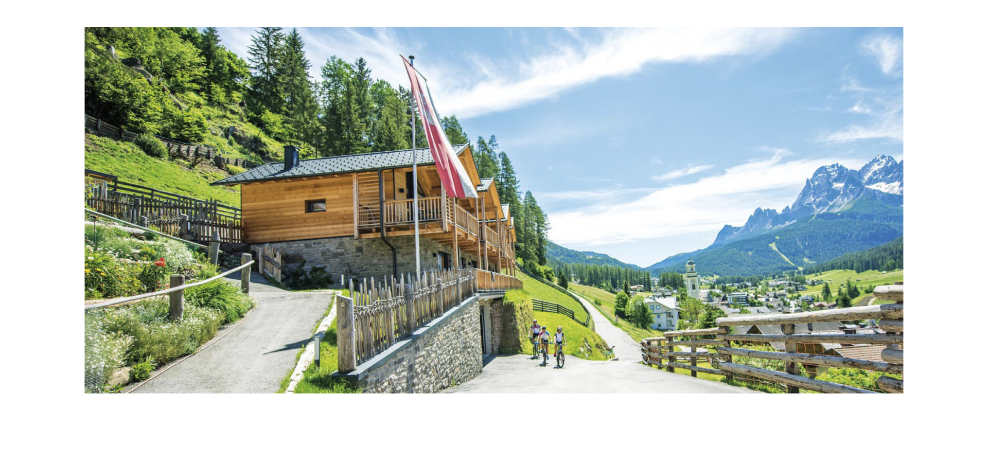 Stabingerhof: Chalets auf dem Bauernhof in den Südtiroler Dolomiten Der Stabingerhof von seiner Seitenansicht mit Blick auf die Sextner Dolomiten und das Dorf