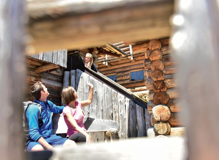 Stabingerhof: Aktivurlaub in den Sextner Dolomiten Eine Familie vor einer Holzhütte in den Bergen Südtirols