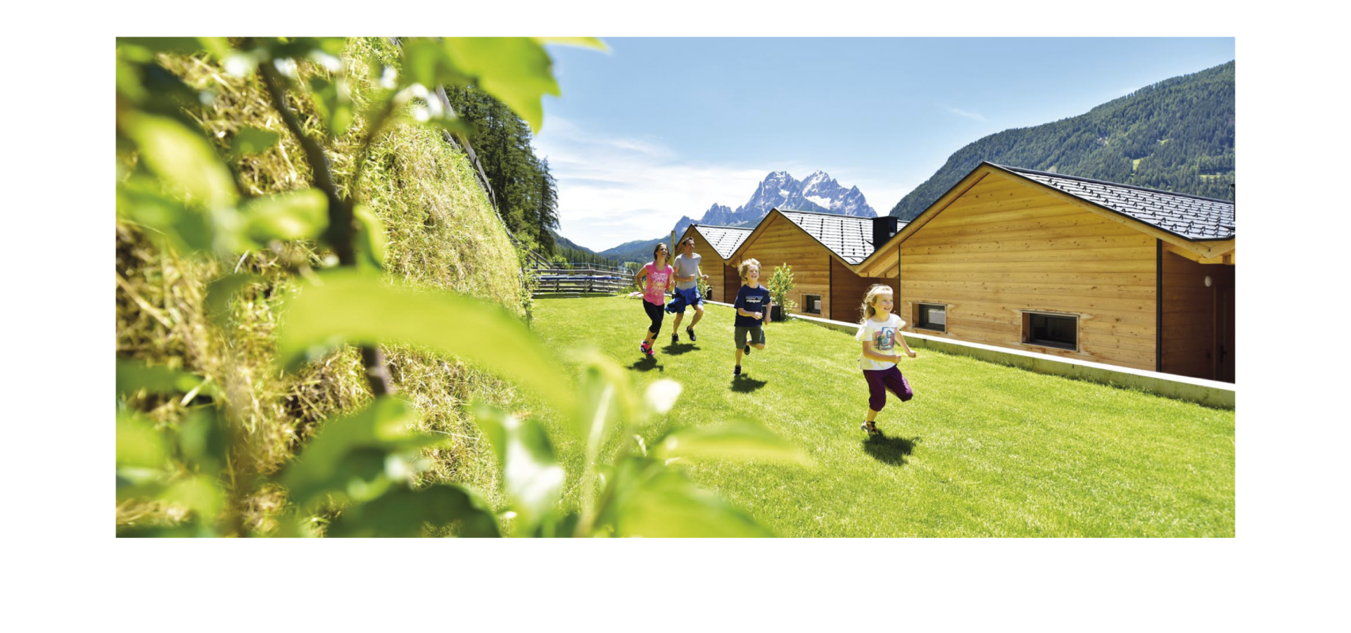 Stabingerhof: Spaß für die ganze Familie Familie im Garten hinter den Chalets vom Stabingerhof